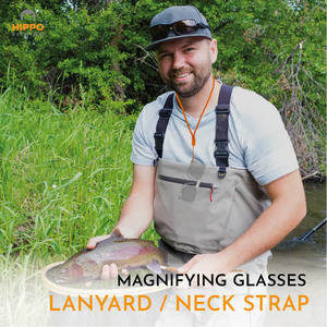 Fly fisherman holding trout and using single handed magnifying glasses on neck lanyard