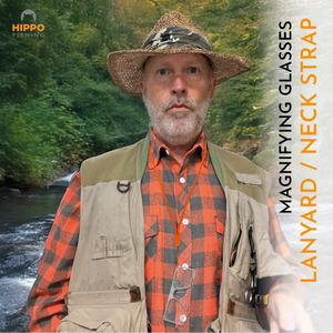 Man wearing single handed magnifying glasses with lanyard for fly fishing in forest river environment