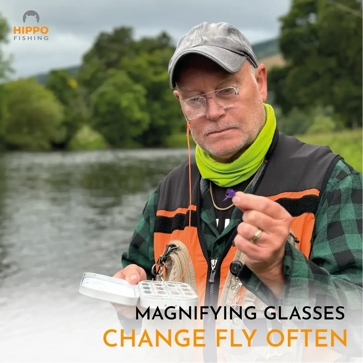 Angler inspecting a fly using magnetic fly fishing magnifier 8275 beside the river.
