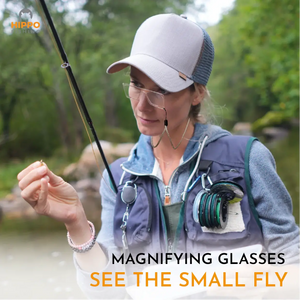 Angler using fly fishing magnifier grey lanyard 8279 for detailed fly tying and knot work in the field.