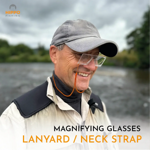 Fly fisherman wearing single handed magnifying glasses with neck strap for hands free fly tying.